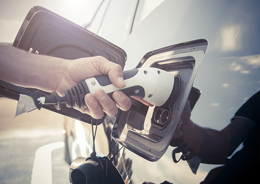 Närbild på person som laddar elbil